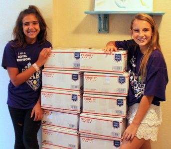 Graci Tubbs and friend with a large stack of care packages.