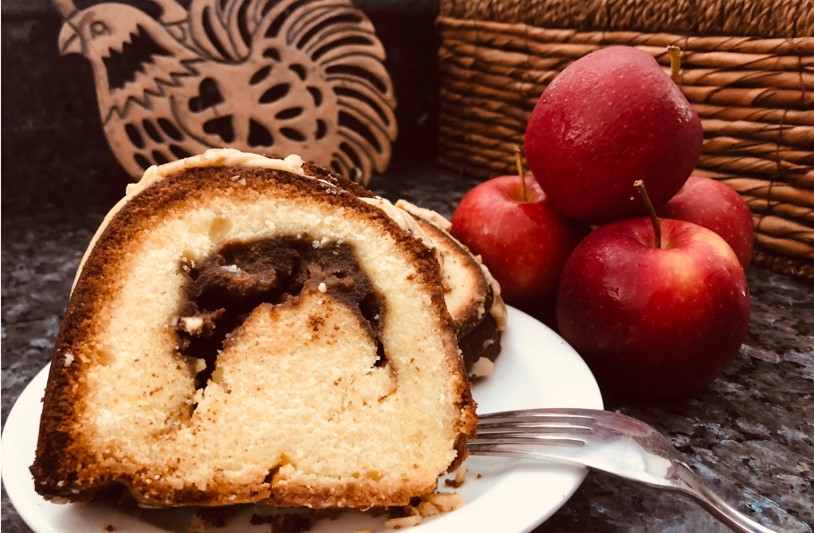 apple bundt cake next to a stack of apples