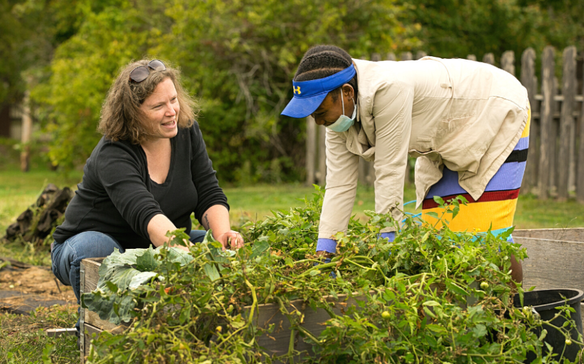 Nation of Neighbors recipient Ann McGlynn working with a refugee in the garden.