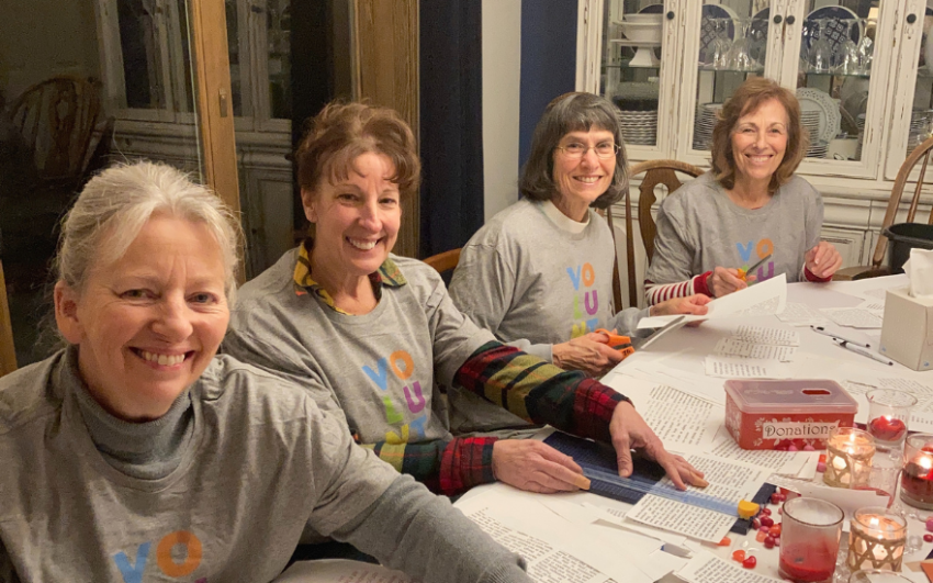 Chapter members working on a project around a dining room table