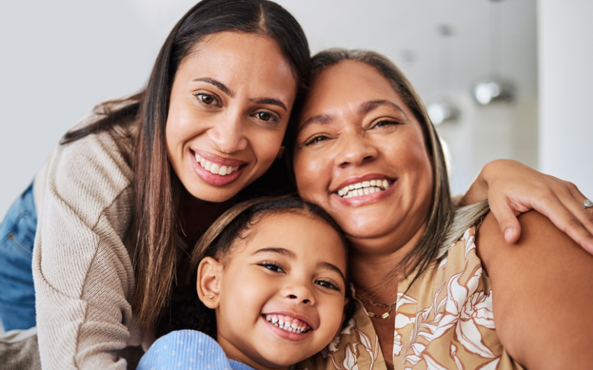 Three generations sharing a warm embrace.