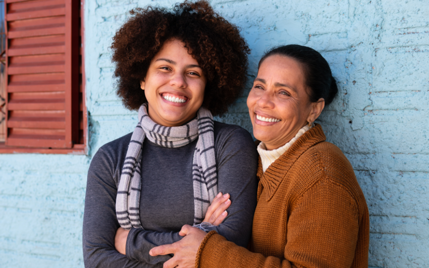 Mother and daughter hugging with big bright smiles