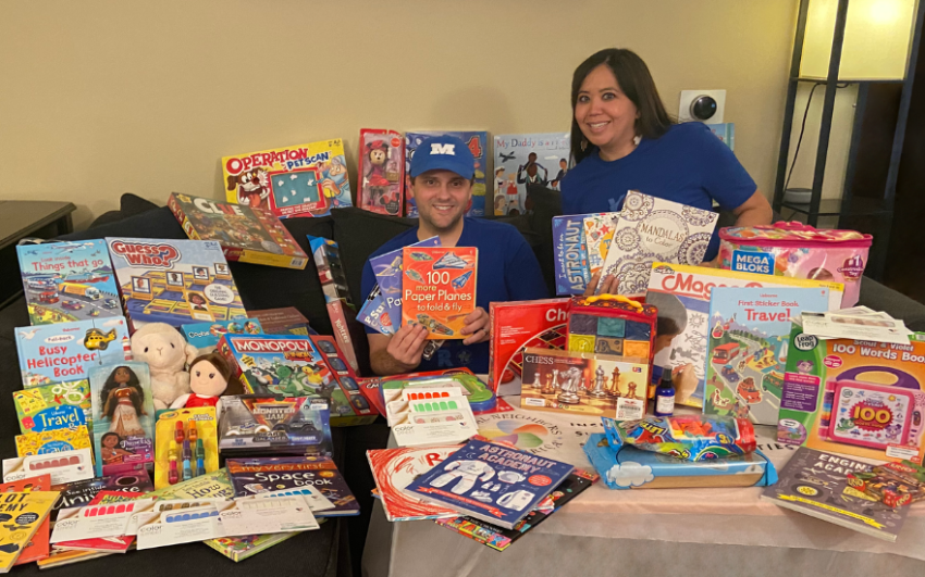 Member and employee Carrie Mail surrounded by toys and games to give to local children.