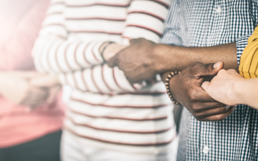 Friends holding hands to form a human chain