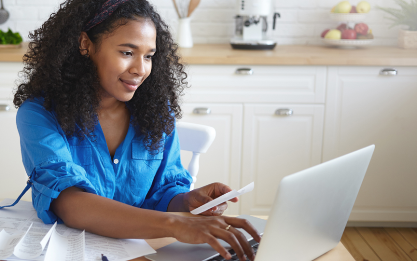 Young woman building a budget on her laptop.