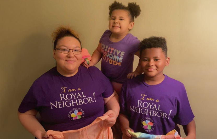 Mother with daughter and son holding clothing to donate.