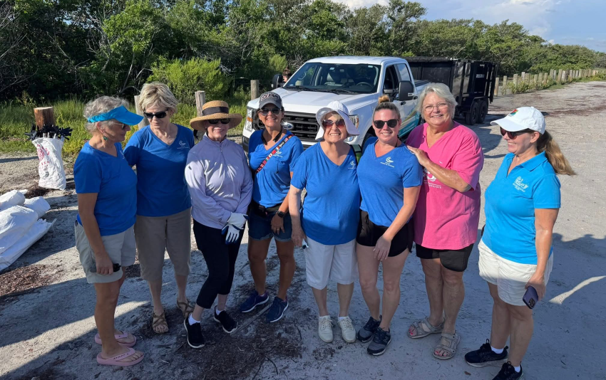 Happy group of volunteers at a beach cleanup event.